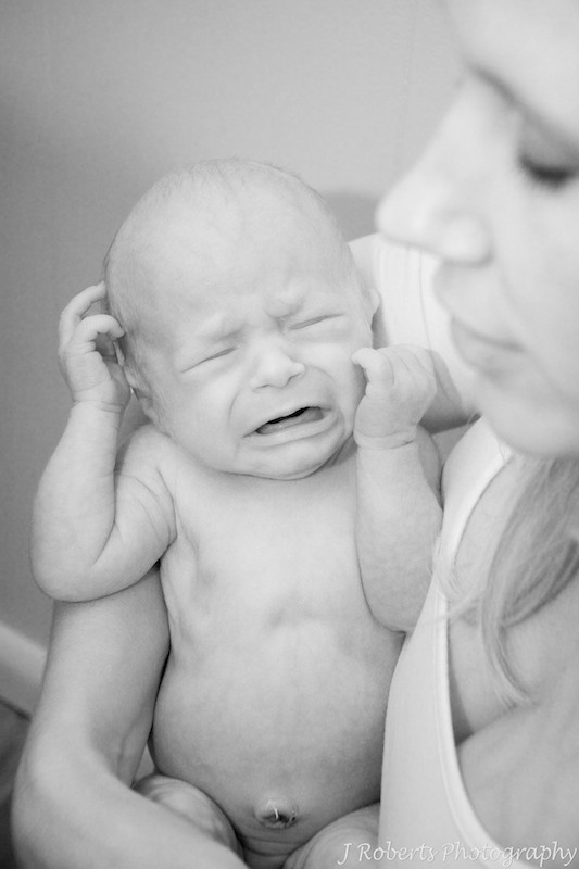 Crying newborn baby on mothers arms - newborn baby photography sydney